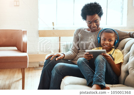 Mother, child and tablet for watching entertainment, movie or elearning on living room sofa together at home. Happy black mom relaxing with son on couch with touchscreen enjoying wifi, games or music Mother, child and tablet for watching entertainment, movie or elearning on living room sofa together at home. Happy black mom relaxing with son on couch with touchscreen enjoying wifi, games or music 105001368