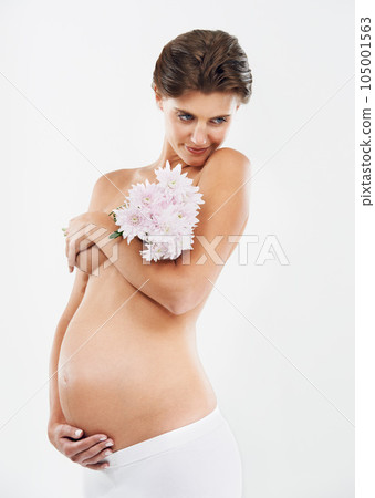 Pregnancy, abdomen and woman with flowers for motherhood on a white background in studio. Smile, stomach and pregnant woman with a bouquet of Deutzia for love of a child on a studio background Pregnancy, abdomen and woman with flowers for motherhood on a white background in studio. Smile, stomach and pregnant woman with a bouquet of Deutzia for love of a child on a studio background 105001563