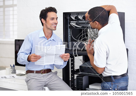 Server room, it support and manual with a technician talking to a business man about instructions to follow. Network, database and installation with an engineer chatting about information technology Server room, it support and manual with a technician talking to a business man about instructions to follow. Network, database and installation with an engineer chatting about information technology 105001565