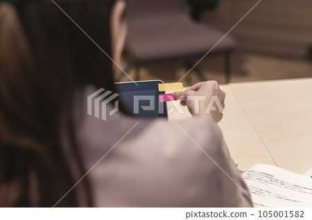 Woman's hand putting a sticky note on a laptop Woman's hand putting a sticky note on a laptop 105001582