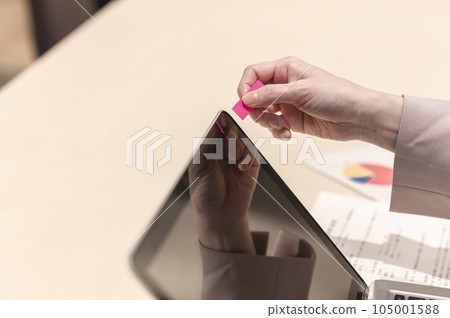 女人的手在筆記本電腦上貼一張便利貼 女人的手在筆記本電腦上貼一張便利貼 105001588