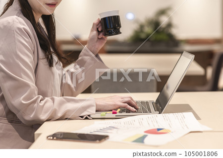 一個女人一邊喝酒一邊工作 一個女人一邊喝酒一邊工作 105001806