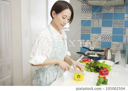 Woman cutting paprika in the kitchen 105002504