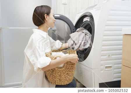 中年婦女從洗衣機裡取出要洗的衣服 中年婦女從洗衣機裡取出要洗的衣服 105002532