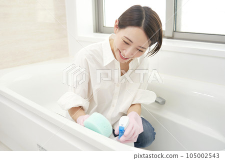 Middle-aged woman cleaning the bath Middle-aged woman cleaning the bath 105002543