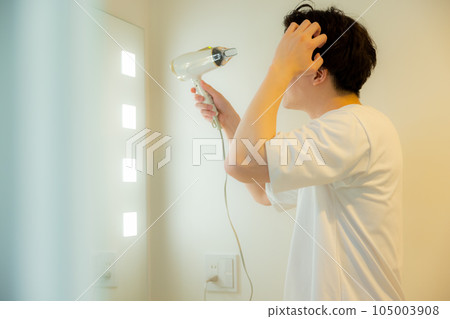 man looking in the mirror in the bathroom man looking in the mirror in the bathroom 105003908