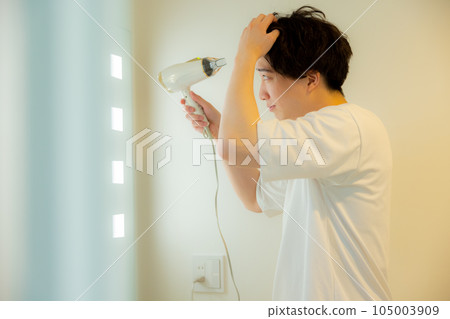man looking in the mirror in the bathroom man looking in the mirror in the bathroom 105003909
