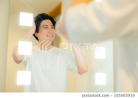 man looking in the mirror in the bathroom 105003910