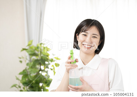 一個微笑著拿著洗滌劑的女人 105004131