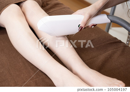 在腿上進行脫毛的婦女的手 在腿上進行脫毛的婦女的手 105004197