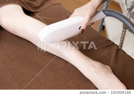 在腿上進行脫毛的婦女的手 在腿上進行脫毛的婦女的手 105004198
