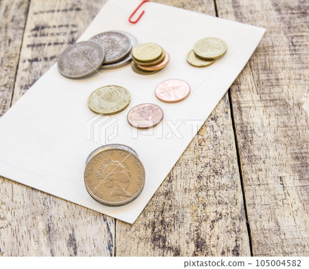 Coin on white paper on wooden table 105004582