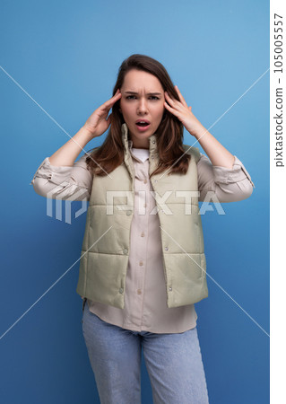upset concentrated brunette young woman in vest and shirt in studio 105005557