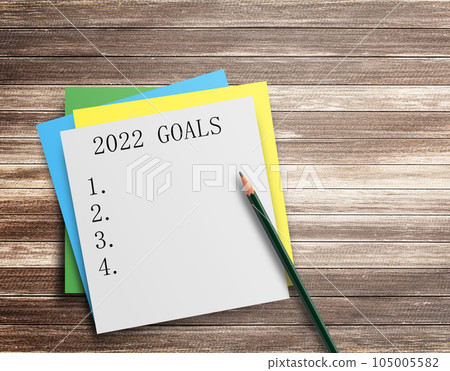 Writing note showing 2022 GOALS on wood table background. 105005582