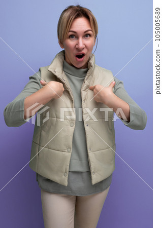 European 30 year old woman is trying to explain her opinion on a studio blue background 105005689
