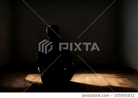 Back view of a man holding his knees alone in a dark room 1: AI-generated image 105005832