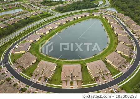 Aerial view of tightly located family houses with retention ponds to prevent flooding in Florida closed suburban area. Real estate development in american suburbs 105006258