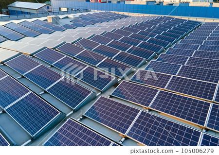 Aerial view of solar power plant with blue photovoltaic panels mounted on industrial building roof for producing green ecological electricity. Production of sustainable energy concept 105006279