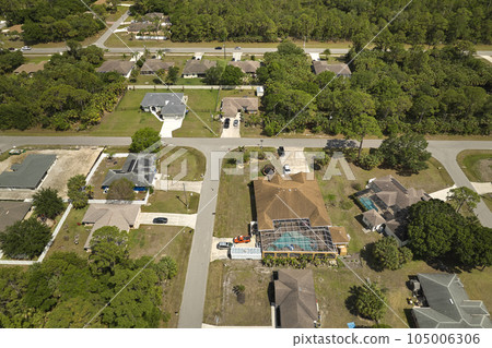 Aerial view of small town America suburban landscape with private homes between green palm trees in Florida quiet residential area 105006306