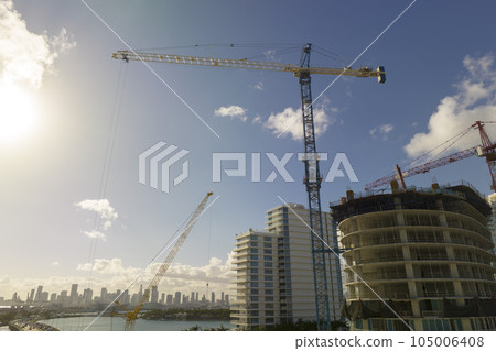 Aerial view of new developing residense in american urban area. Tower cranes at industrial construction site in Miami, Florida. Concept of housing growth in the USA Aerial view of new developing residense in american urban area. Tower cranes at industrial construction site in Miami, Florida. Concept of housing growth in the USA 105006408