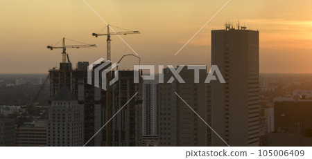 Aerial view of new developing residense in american urban area at sunset. Tower cranes at industrial construction site in Miami, Florida. Concept of housing growth in the USA Aerial view of new developing residense in american urban area at sunset. Tower cranes at industrial construction site in Miami, Florida. Concept of housing growth in the USA 105006409