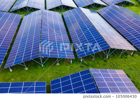 Aerial view of large sustainable electrical power plant with rows of solar photovoltaic panels for producing clean ecological electric energy. Renewable electricity with zero emission concept. Aerial view of large sustainable electrical power plant with rows of solar photovoltaic panels for producing clean ecological electric energy. Renewable electricity with zero emission concept. 105006430