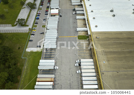 Aerial view of large commercial distribution center with many trucks unloading and uploading retail products for further shipment. Global economy concept 105006441