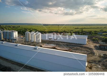 Aerial view of industrial ventilated silos for long term storage of grain and oilseed. Metal elevator for wheat drying in agricultural zone Aerial view of industrial ventilated silos for long term storage of grain and oilseed. Metal elevator for wheat drying in agricultural zone 105006448