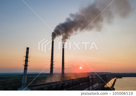Aerial view of coal power plant high pipes with black smoke moving upwards polluting atmosphere at sunset. Production of electrical energy with fossil fuel concept 105006519