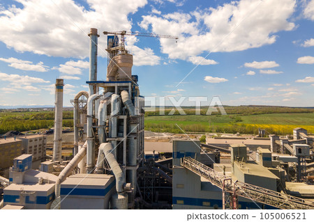Aerial view of cement plant with high concrete factory structure and tower crane at industrial production area. Manufacture and global industry concept. Aerial view of cement plant with high concrete factory structure and tower crane at industrial production area. Manufacture and global industry concept. 105006521