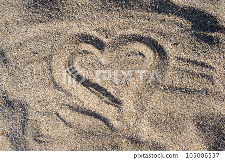 Drawing heart shape love concept on sand at the beach with vacation holiday summer travel background. Heart shape and footprint on sand. Drawing heart shape love concept on sand at the beach with vacation holiday summer travel background. Heart shape and footprint on sand. 105006537