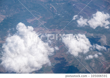 Big white clouds in a blue sky close-up. View of the clouds from the sky, and under the clouds the earth. There is a place for the text. The concept of cleanliness in nature and caring for nature 105006591