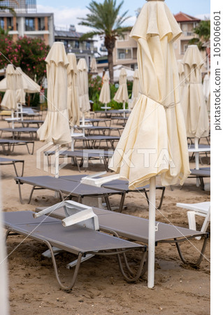 Beach in Antalya, Turkiye. Umbrellas and sun loungers in the assembled state on the beach. Beach in Antalya, Turkiye. Umbrellas and sun loungers in the assembled state on the beach. 105006601
