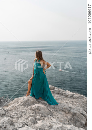 Woman sea green dress. Side view a happy woman with long hair in a long mint dress posing on a beach with calm sea bokeh lights on sunny day. Girl on the nature on blue sky background. Woman sea green dress. Side view a happy woman with long hair in a long mint dress posing on a beach with calm sea bokeh lights on sunny day. Girl on the nature on blue sky background. 105006617