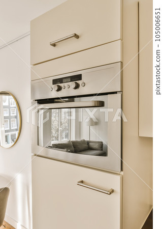 a kitchen with an oven in the middle and a chair on the other side next to the stove is empty 105006651