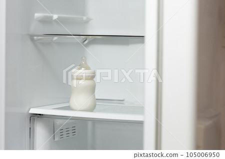 Bottle feeding full of milk on lower shelf of refrigerator for storage Bottle feeding full of milk on lower shelf of refrigerator for storage 105006950