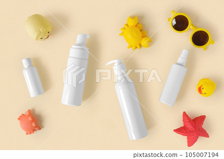 Sunscreen lotion tube on neutral background. Plastic bottle of sun protection and kids sunglasses and sandbox toys on beige table. Children skin care concept. Sunscreen for children. Baby Cosmetic Sunscreen lotion tube on neutral background. Plastic bottle of sun protection and kids sunglasses and sandbox toys on beige table. Children skin care concept. Sunscreen for children. Baby Cosmetic 105007194