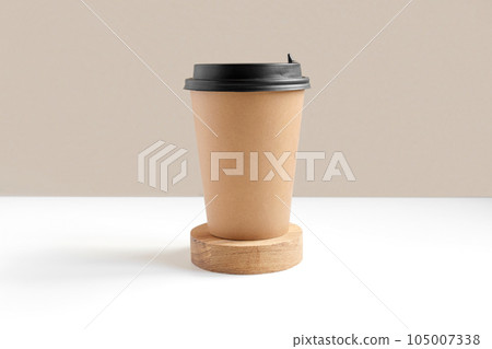 Front view of a Brown coffee paper cup. Mockup with lid. Set of craft paper cups for coffee or tea on beige background. Zero waste, plastic free concept. Disposable Recycled cups. Wooden podium 105007338