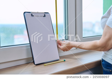 Woman measuring window with tape measure, tailoring service Woman measuring window with tape measure, tailoring service 105008097