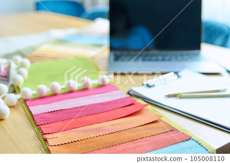 Workplace of designer, decorator, samples of fabrics and accessories recording notebook on table 105008110