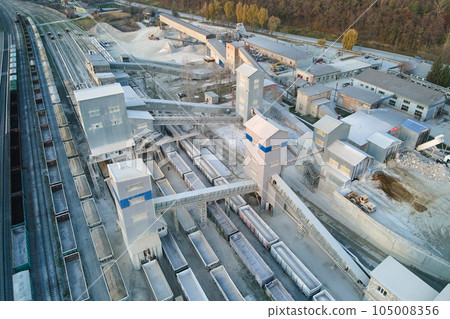 Aerial view of cargo train loaded with crushed stone materials at mining factory. Railway transportation of grinded limestone ore 105008356