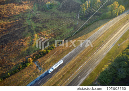 Aerial view of busy american freeway with fast moving cars and trucks. Interstate hauling of goods concept Aerial view of busy american freeway with fast moving cars and trucks. Interstate hauling of goods concept 105008360