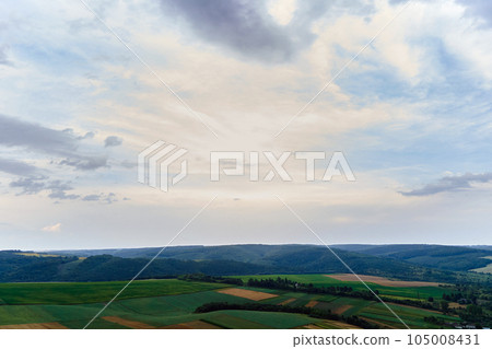 Aerial landscape view of green cultivated agricultural fields with growing crops on bright summer day Aerial landscape view of green cultivated agricultural fields with growing crops on bright summer day 105008431
