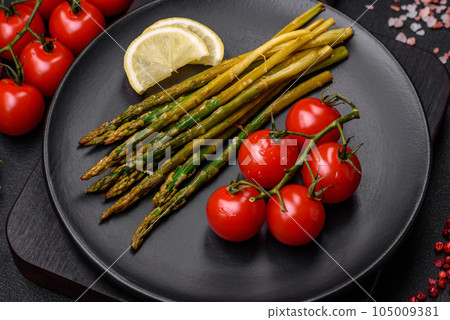 Delicious nutritious breakfast consisting of asparagus, tomatoes, salt, spices and herbs 105009381
