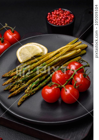 Delicious nutritious breakfast consisting of asparagus, tomatoes, salt, spices and herbs Delicious nutritious breakfast consisting of asparagus, tomatoes, salt, spices and herbs 105009384
