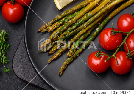 Delicious nutritious breakfast consisting of asparagus, tomatoes, salt, spices and herbs Delicious nutritious breakfast consisting of asparagus, tomatoes, salt, spices and herbs 105009385