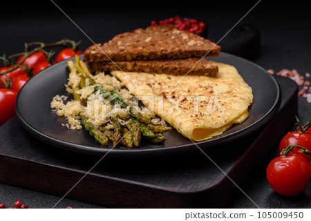 Delicious nutritious breakfast consisting of asparagus, scrambled eggs, salt, spices and herbs Delicious nutritious breakfast consisting of asparagus, scrambled eggs, salt, spices and herbs 105009450