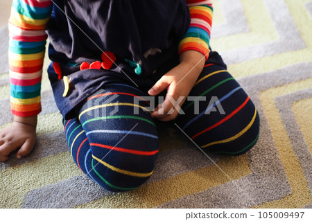 child sitting W posture on the floor . 105009497
