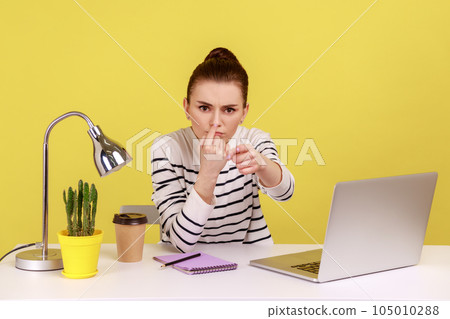 Portrait of bossy serious annoyed woman office manager touching nose, doing liar gesture, looking with suspicion at camera. Indoor studio studio shot isolated on yellow background. 105010288