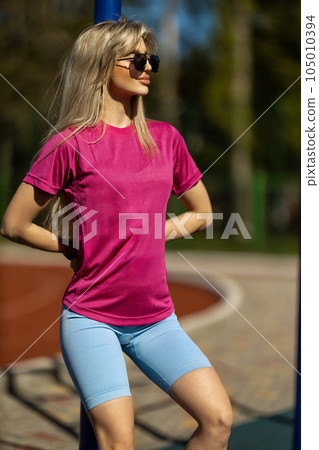 blonde athletic girl stands on the sports ground 105010394